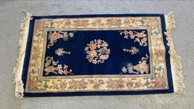 une image représentant un tapis bleu orné d'une bordure dorée et de fleurs
