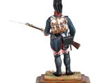 statue of a soldier with a rifle and a backpack on a wooden base