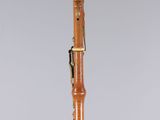 a wooden clarinet with a black tip and gold trim on a clear base