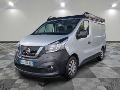 La camionnette argentée est garée sur un sol à damier dans un garage.