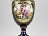 un vase bleu avec une peinture dessus, posé sur une table