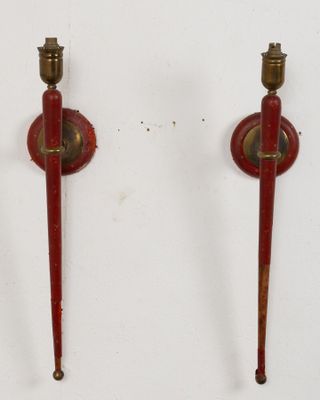 une paire de bougies rouges et en laiton sur fond blanc