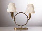 une paire de lampes de table en laiton avec des abat-jours blancs, posées sur une surface blanche