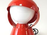 une lampe rouge posée sur une table blanche