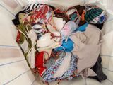 a pile of clothes in a basket on a bed