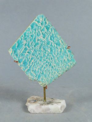 une petite sculpture représentant un diamant bleu sur un socle en marbre