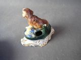 a figurine of a dog sitting on top of a bowl