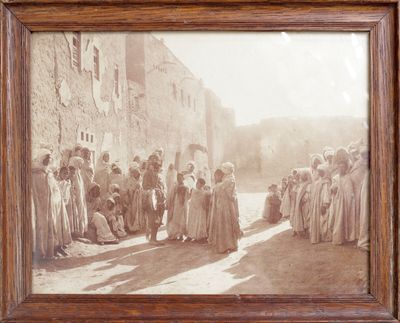 une vieille photo d'un groupe de personnes se tenant devant un bâtiment