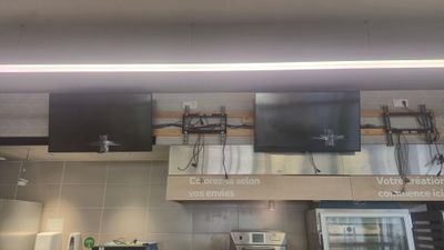 une photo d'une cuisine avec une télévision fixée au mur