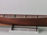 a small wooden boat on a stand on a table