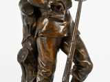 statue en bronze représentant un homme avec un fusil et un chien