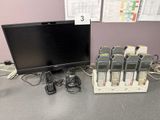 un bureau sur lequel se trouvent un écran et plusieurs téléphones portables