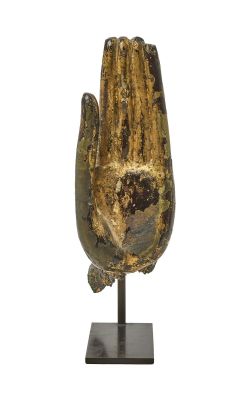 statue représentant une main tenant un morceau de bois, posée sur un socle en métal