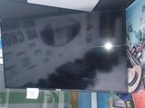 a flat screen tv hanging from the ceiling in a store
