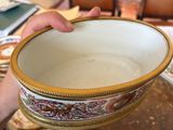 a person holding a bowl that is sitting on a table