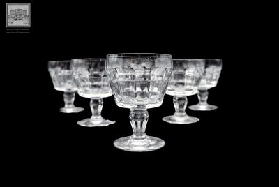 six verres à vin alignés sur un fond noir