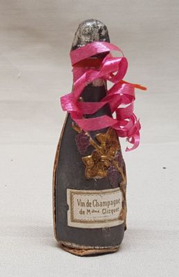une bouteille de champagne ornée d'un ruban rose