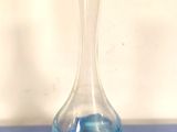 un vase en verre posé sur une table bleue