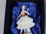 a figurine of a woman in a dress in a box