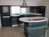une cuisine avec un plan de travail en verre et des placards noirs