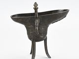 an old metal bowl with a bird on top of it