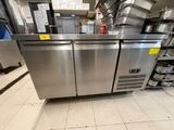 une grande cuisine en inox avec de nombreuses casseroles et poêles posées sur le plan de travail