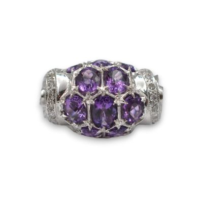 un gros plan d'une bague ornée de pierres violettes sur fond blanc
