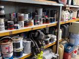 de nombreux pots de peinture posés sur une étagère dans un garage