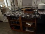a kitchen counter with wine glasses and plates on it
