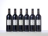 six bottles of wine are lined up on a table
