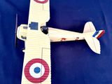 une petite maquette d'avion posée sur une surface bleue