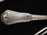 a silver spoon and fork sitting on a black surface