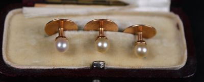 three pairs of cufflinks with pearls in a box
