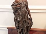 une statue représentant une femme tenant un bébé sur une table en marbre