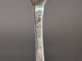 a silver spoon with a piece of cake on it