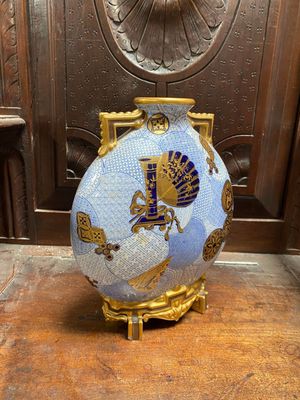 un vase bleu et or posé sur une table en bois