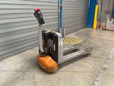 a forklift truck with a fork on it in front of a garage door