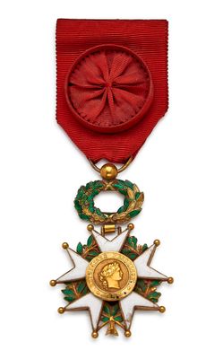 Gros plan sur une médaille sur fond blanc, accompagnée d'un ruban rouge
