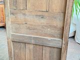 a wooden door that is open on a brick floor