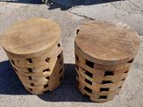 three wooden stools sitting on top of a cement floor next to a bicycle