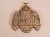 a silver plaque with a cross on it
