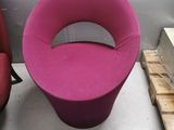 a pink chair and a red chair in a room