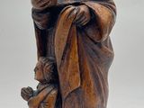 wooden figurine of a monk holding a bottle of wine
