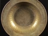 un bol ancien en laiton orné d'un motif circulaire sur le bord