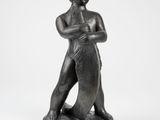 a black statue of a man holding a surfboard on a white background