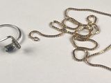 two rings and a chain on a white surface