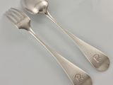 deux cuillères et une fourchette en argent sur une table