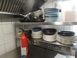 many plates and pans on the shelf in the kitchen