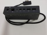 a close up of a black power strip connected to a charger on a white surface