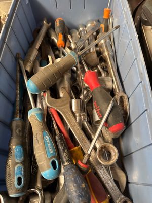 many different tools in a blue bin on the floor